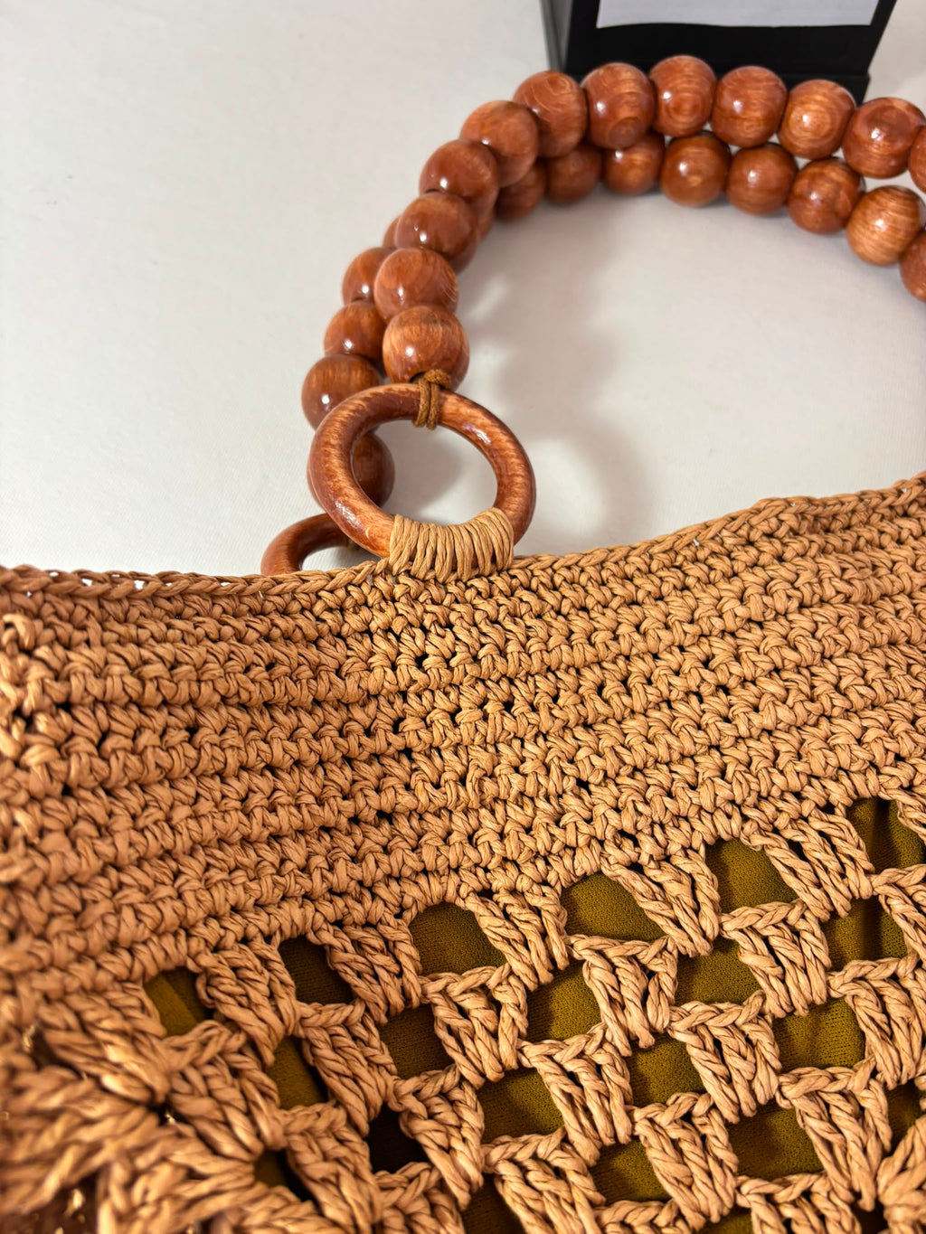 Large handmade raffia beach tote with elegant wooden bead handles and spacious interior for daily essentials.