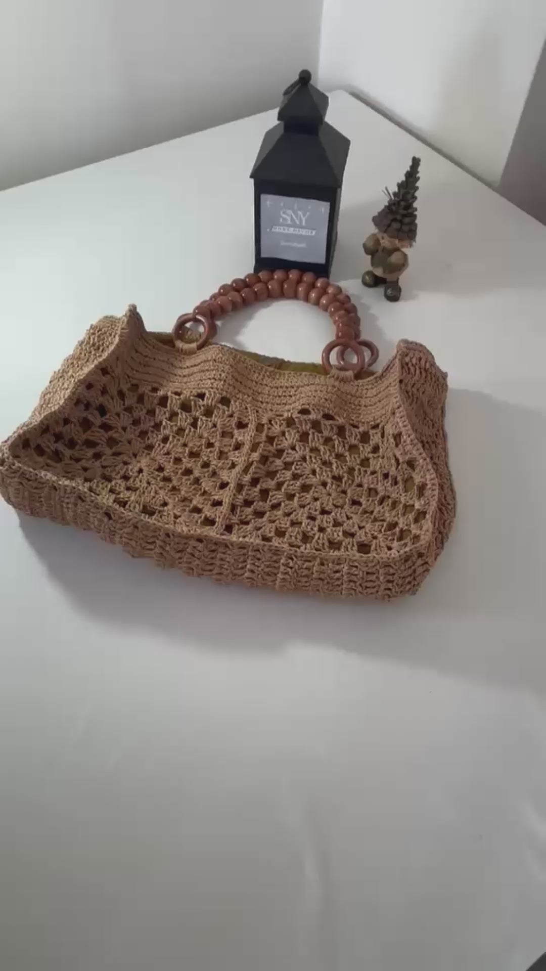 Natural raffia handbag carefully crocheted by hand, featuring a unique open weave pattern and artisan craftsmanship.